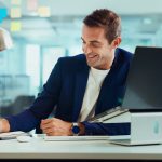 Confident businessman selling a business smiles as he works.
